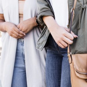 close up shot of two women's torsos, both wearing jeans and showing their hands