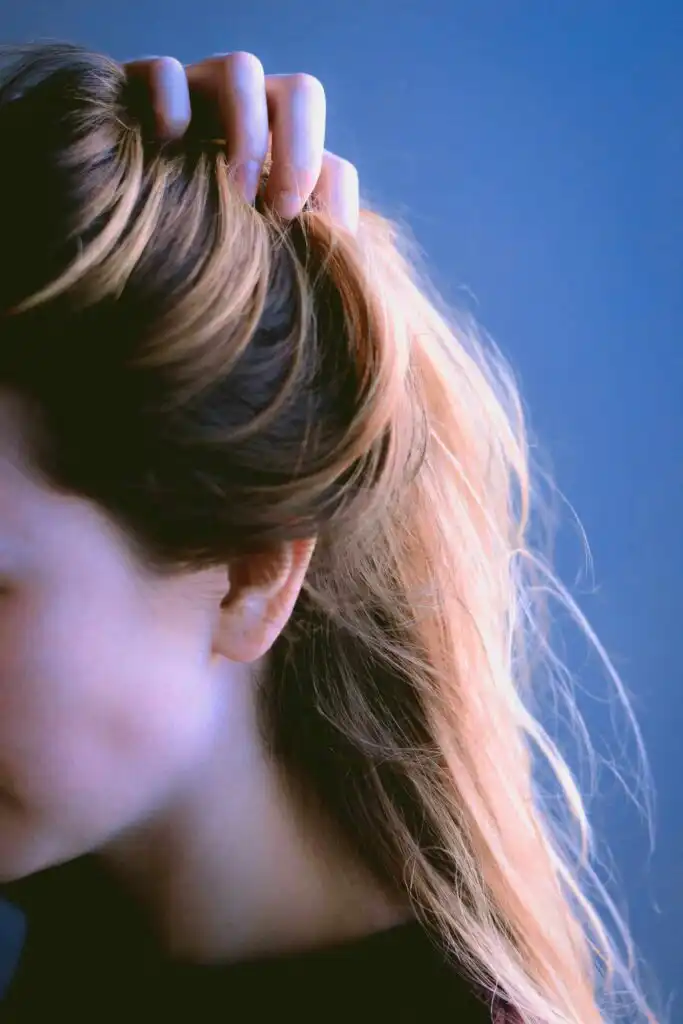 Nutrients for hair loss for vegetarians 1 Woman close up lifting up her hair - IBS and hair loss