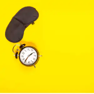 fatigue in IBS (1) yellow background, black eye mask and alarm clock