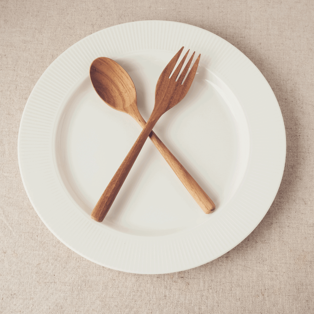wooden knife and fork on a white empty plate