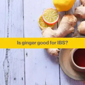 root ginger, some cut lemons and a cup of black tea against a light blue wooden boarded table