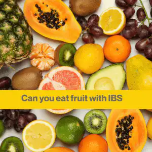 Flat lay of fruits including papaya, orange, lemons, kiwi, pineapple, pink grapefruit, lime, red grapes.