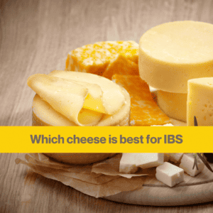 a pile of round, yellow cheeses on a round board on a wooden table. The words Which cheese is best for IBS
