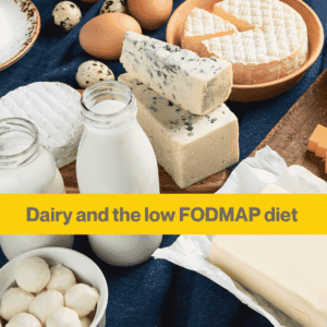 Table spread with dark blue cloth, and two bottles of milk in glass bottles, some cheese on a wooden board, a white bowl holding some cheese balls.