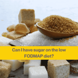 Close up of piles of brown and white sugar, and some sugar cubes near the front of the image. 