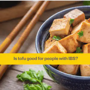 Blue china bowl with lumps of fried tofu, some wooden chopsticks are resting on the table next to the bowl
