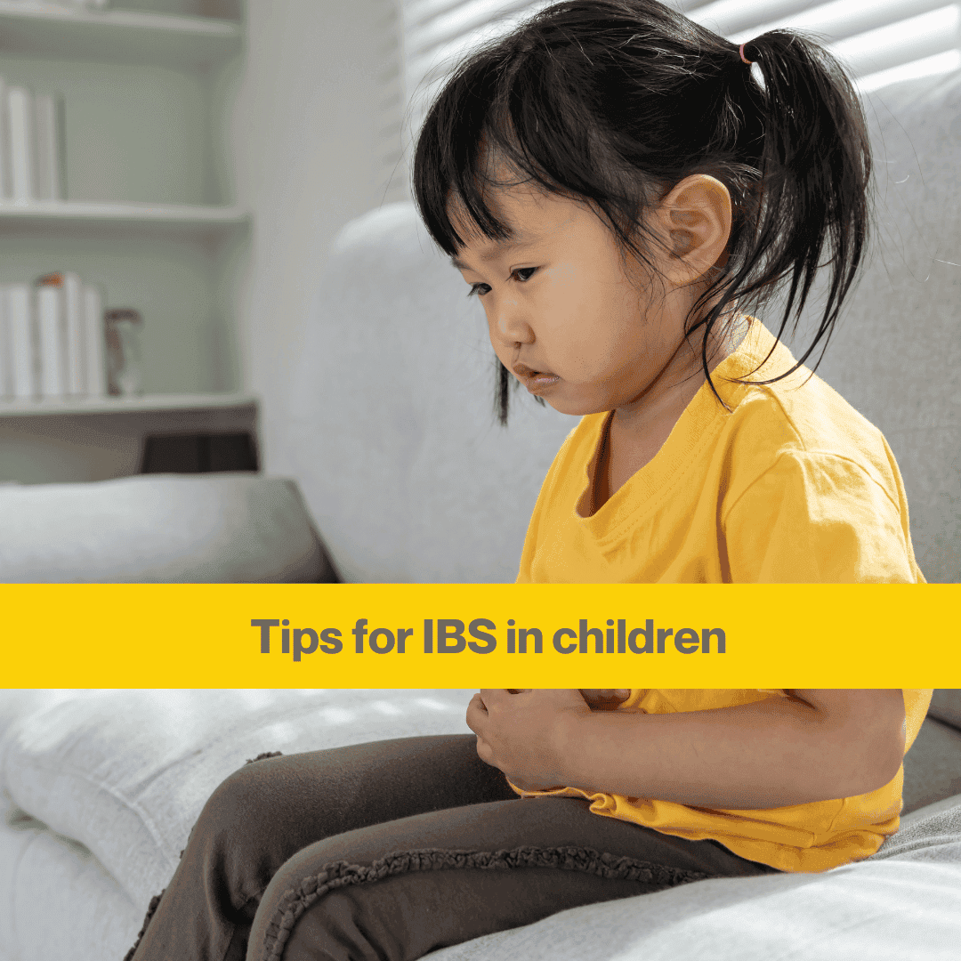 Small girl wearing a yellow t shirt holding her stomach. Words Tips for IBS in children