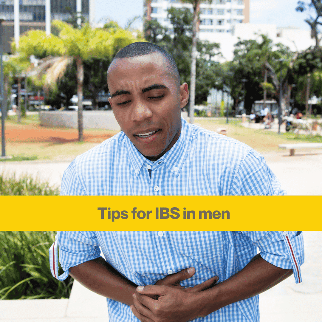 Young man with shaved head clutching his stomach outside an office block. Wearing a thinly striped blue and white shirt. Words Tips for IBS in med 