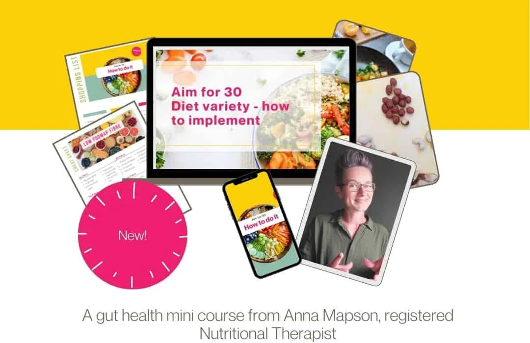 Nutritionist reviewing a meal plan with a man seated at a table, with fruits, a clipboard, and healthy food items visible in a bright kitchen setting.
