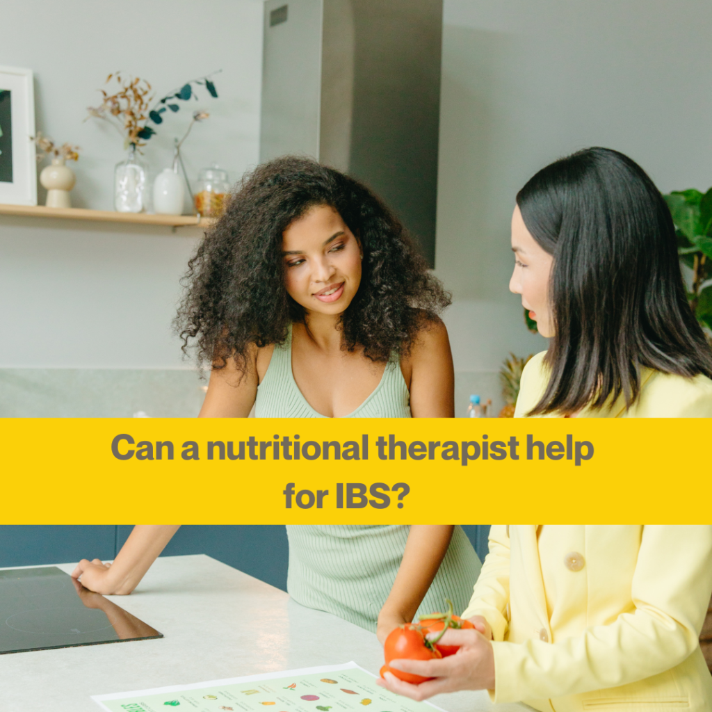 Nutritionist vs dietitian for IBS: what's the difference? 2 Two women chatting in a kitchen looking at some charts and tomatoes. Words Can a nutritional therapist help for IBS.